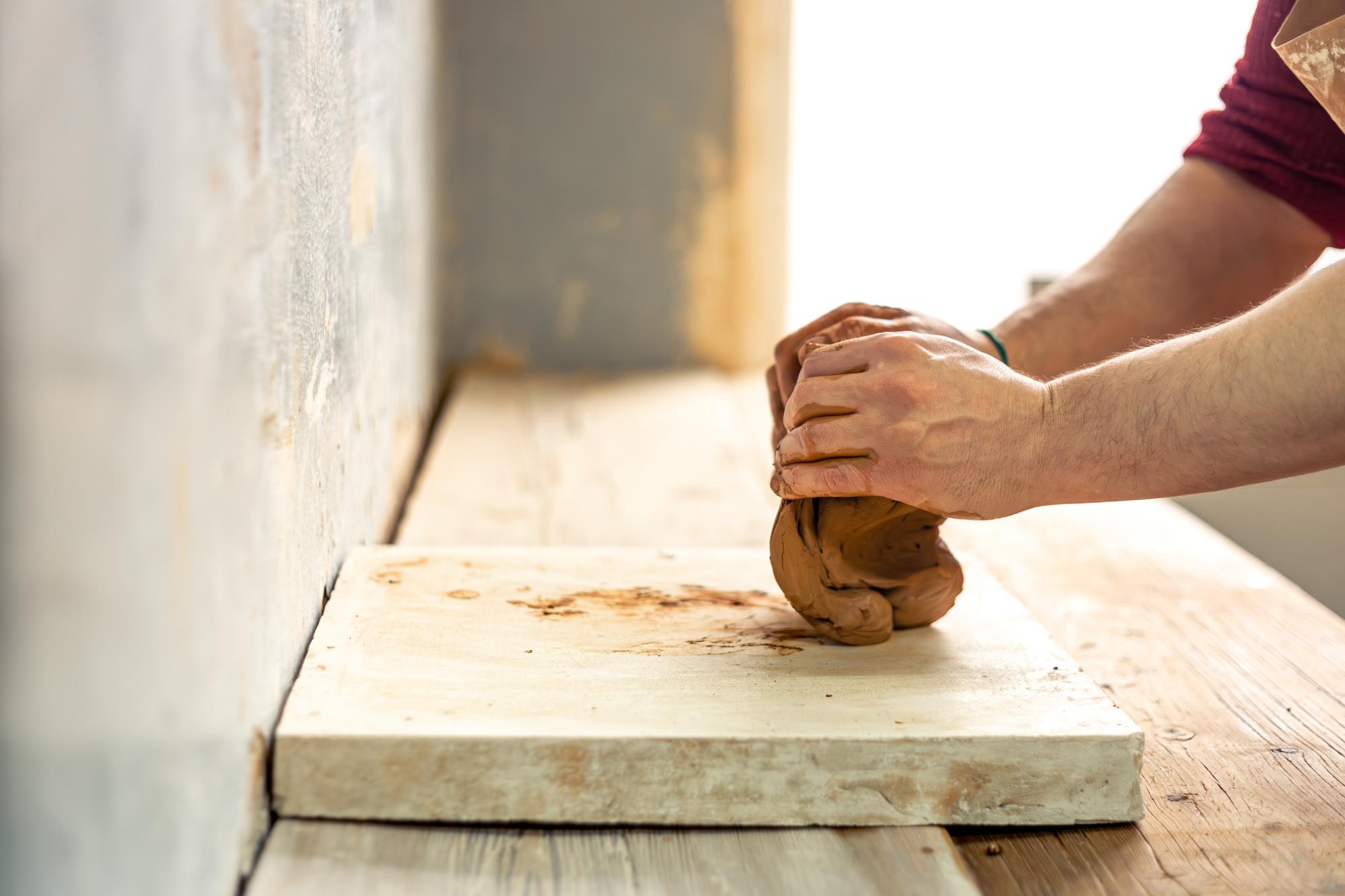 Hands preparing dough on wooden table